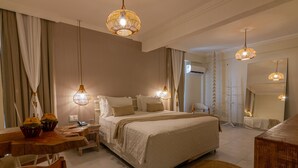 Une chambre d’hôtel avec un grand lit, des meubles en bois et des lampes suspendues.