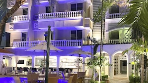 Un hôtel doté d’une piscine, d’un espace extérieur aménagé et d’une entrée bien éclairée.