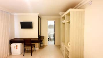 A compact hotel room with a kitchenette, a small dining area, and a wardrobe.