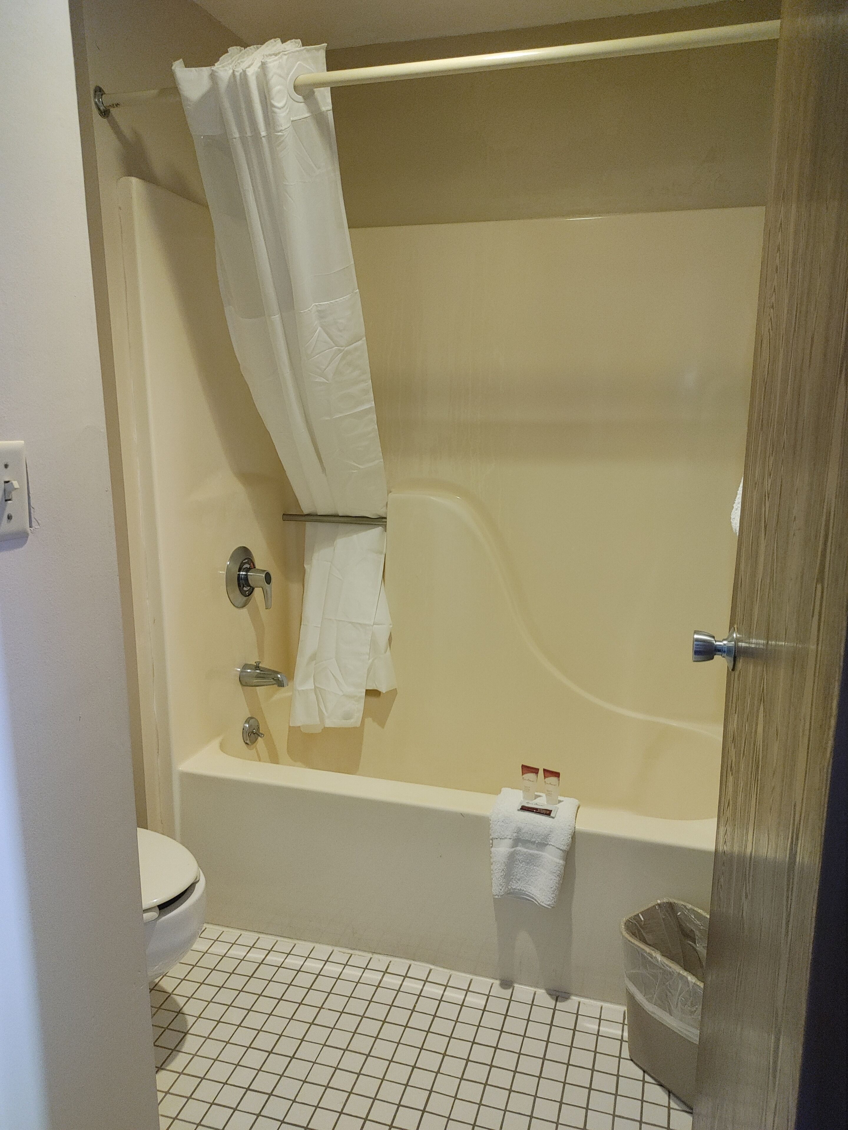 Un baño con bañera, inodoro y cortina de ducha.