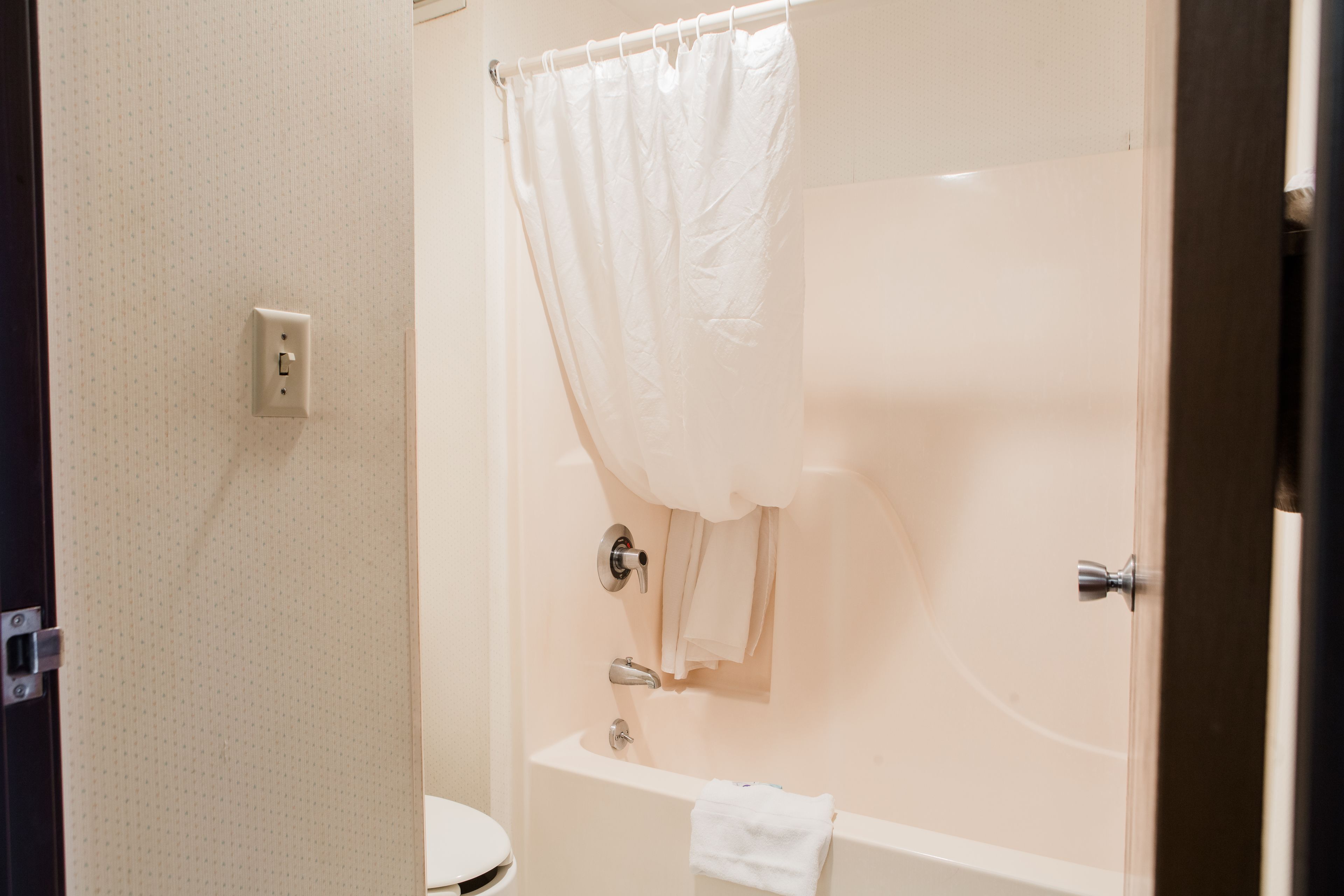 Un bagno con una vasca, un water e una tenda da doccia.