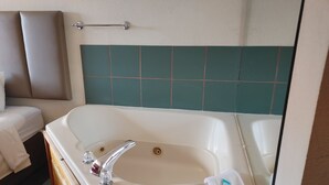A bathroom with a large bathtub, a shower, and a toilet.