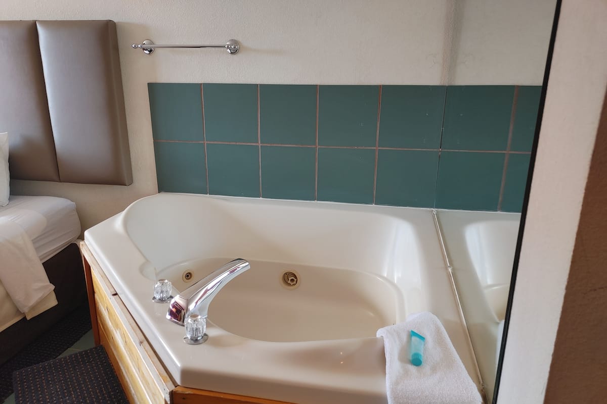 A bathroom with a large bathtub, a shower, and a toilet.