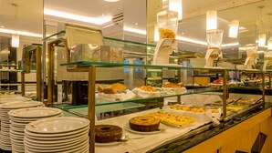 A buffet with various food items and a cake on display.