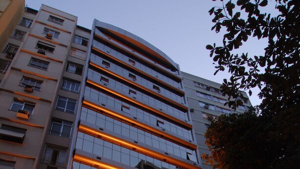 Un hotel de varios pisos con un diseño moderno, que destaca por una entrada imponente con señalización iluminada.