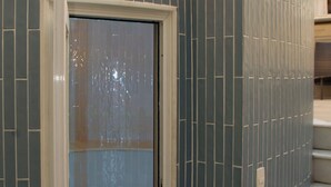 Una pared curva con una puerta que da a una habitación con piso de baldosas.