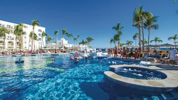 Relax by the pool surrounded by palm trees and enjoy a hot tub and lounge chairs.