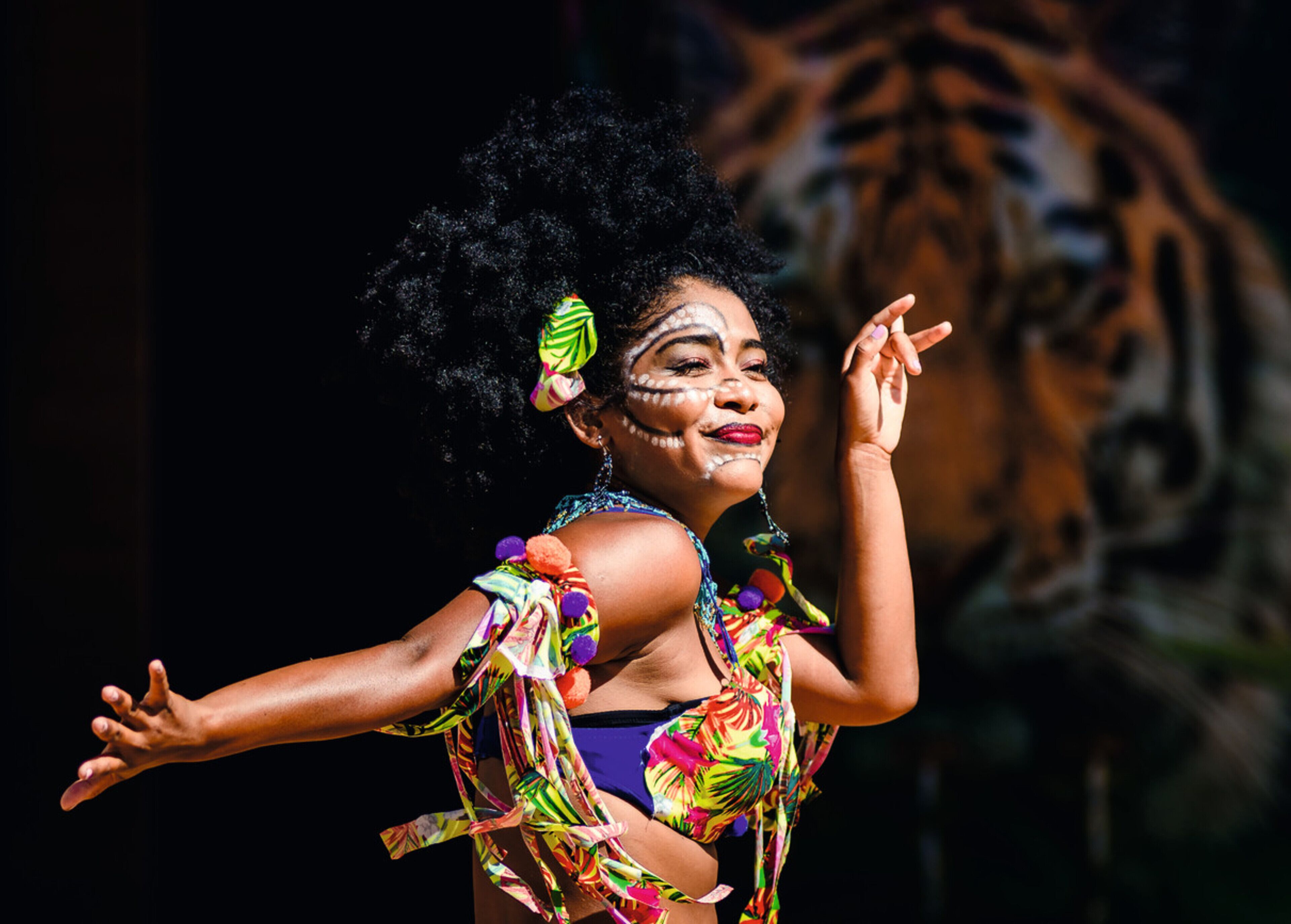 A person in a colorful costume with a tropical print, performing a dance.