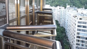 Un edificio alto con un balcón de cristal.