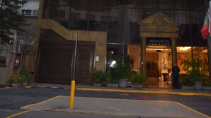 Un hotel de varios pisos con un diseño arquitectónico distintivo, que cuenta con balcones y una entrada central.