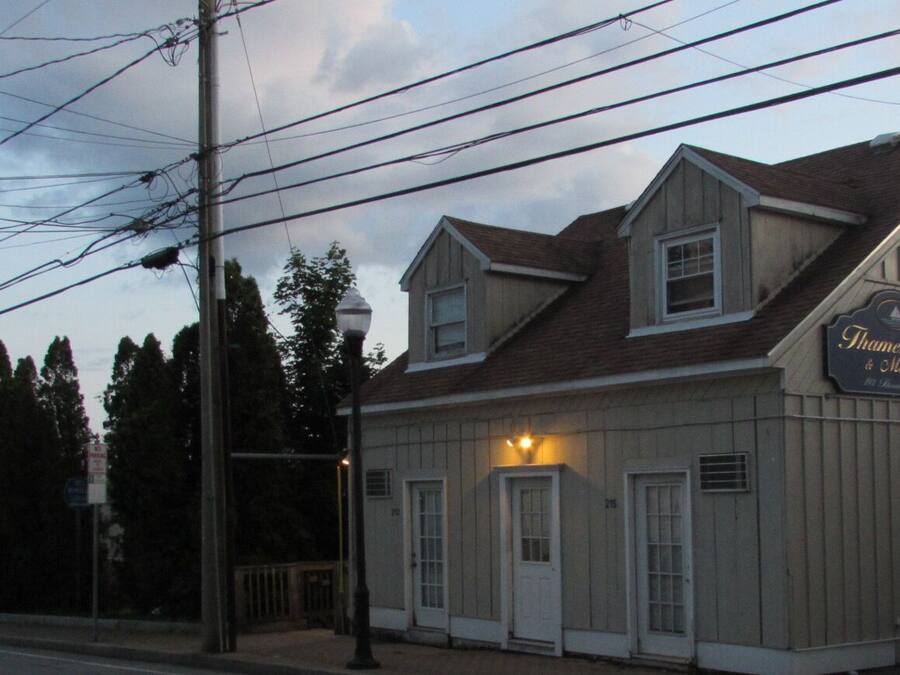A two-story building with a sign reading "Thames Inn & Marina."