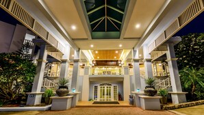 A hotel entrance with a central staircase, a covered walkway, and potted plants. - Andaman Seaview Hotel (Karon)