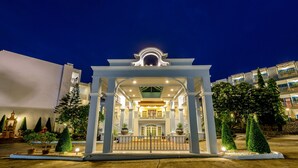 A hotel entrance with a covered walkway, potted plants, and a well-lit facade. - Andaman Seaview Hotel (Karon)
