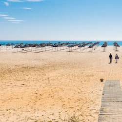Am Strand, weißer Sandstrand, Liegestühle, Sonnenschirme