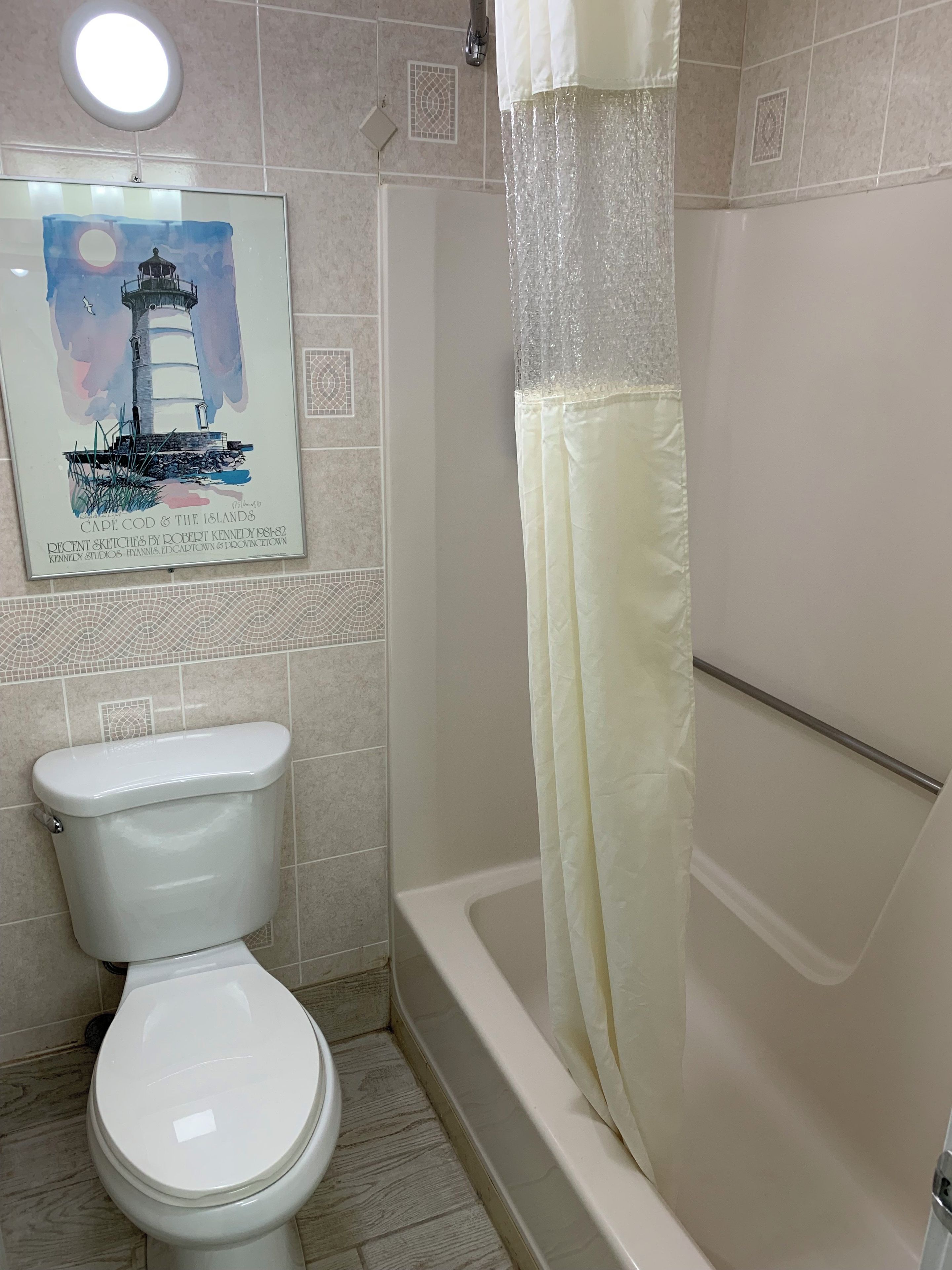 A bathroom with a toilet, a bathtub, and a shower curtain.