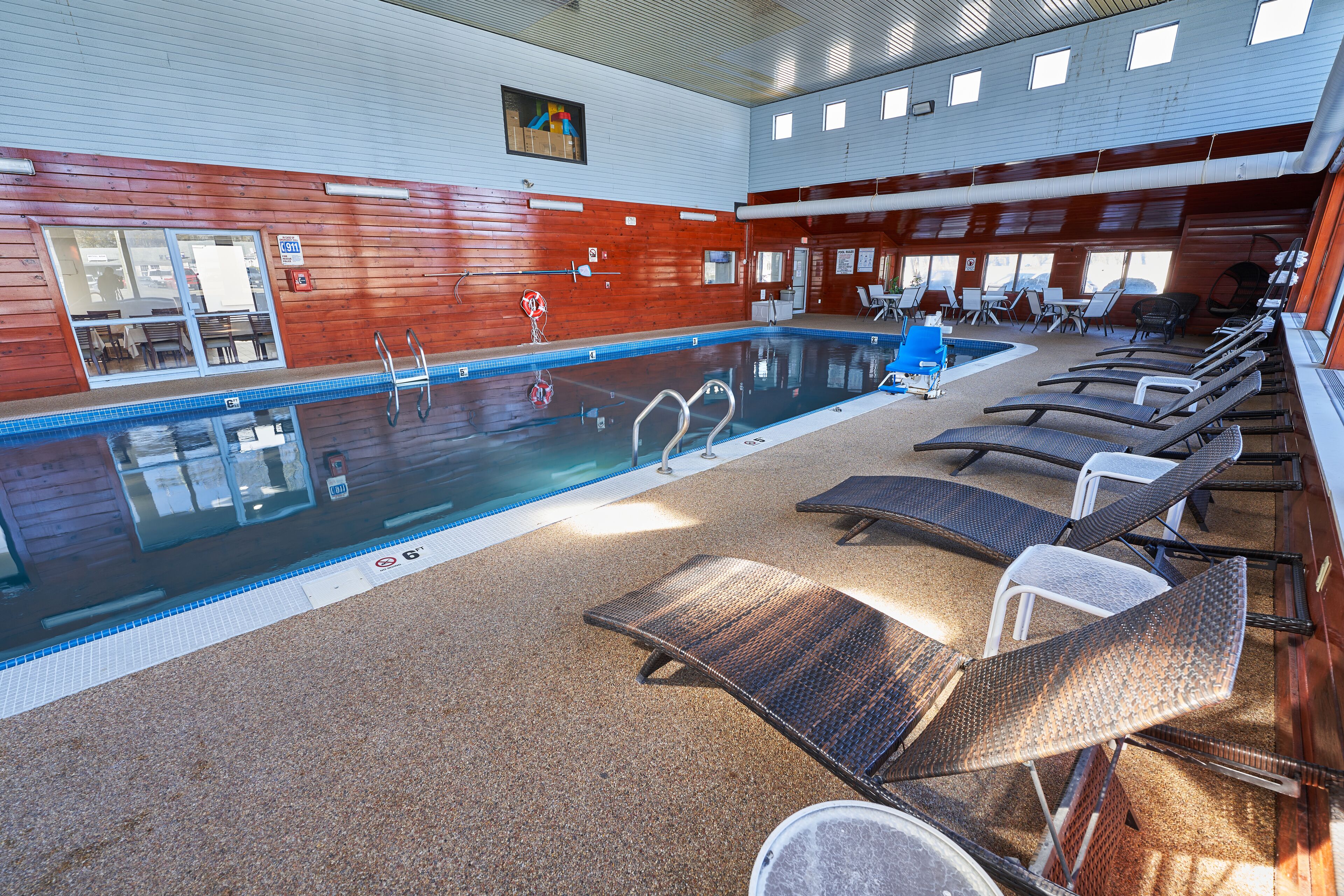 Una piscina interior con sillones de descanso y vistas al exterior.