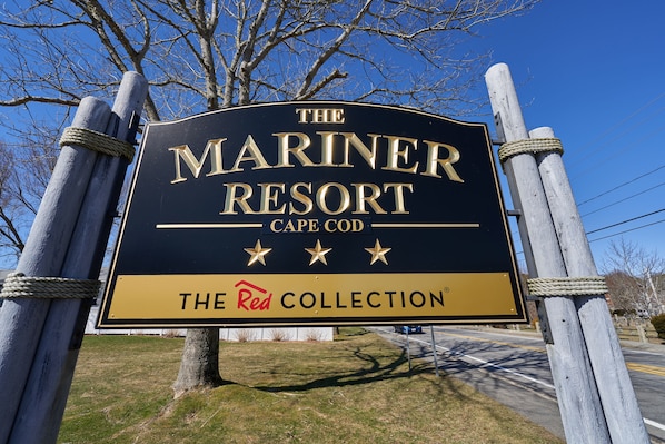 A sign for The Mariner Resort in Cape Cod, featuring a prominent logo and the text "The Red Collection". - The Mariner Resort Cape Cod by The Red Collection (West Yarmouth)