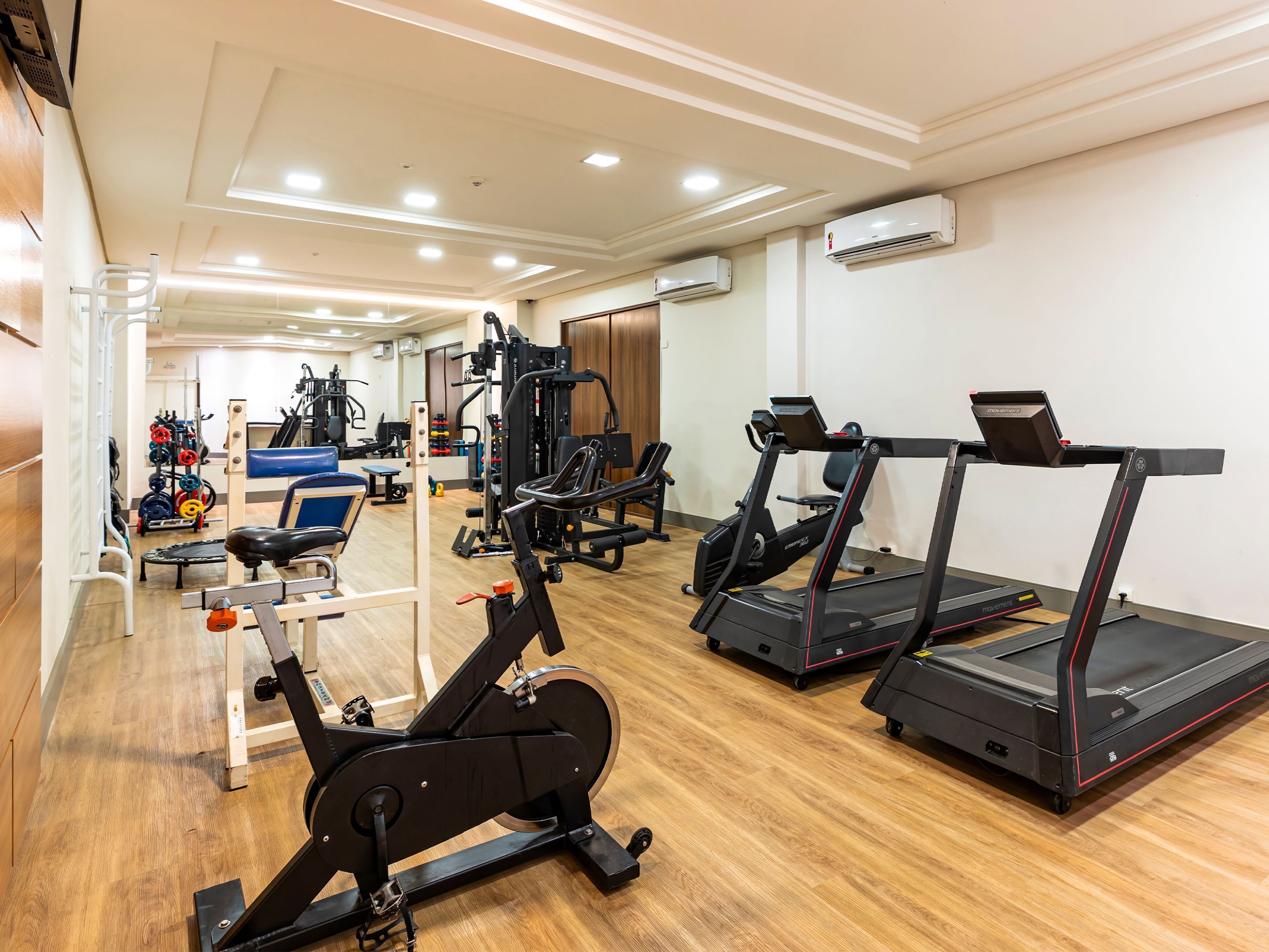 A gym with treadmills, an elliptical, and weightlifting equipment.