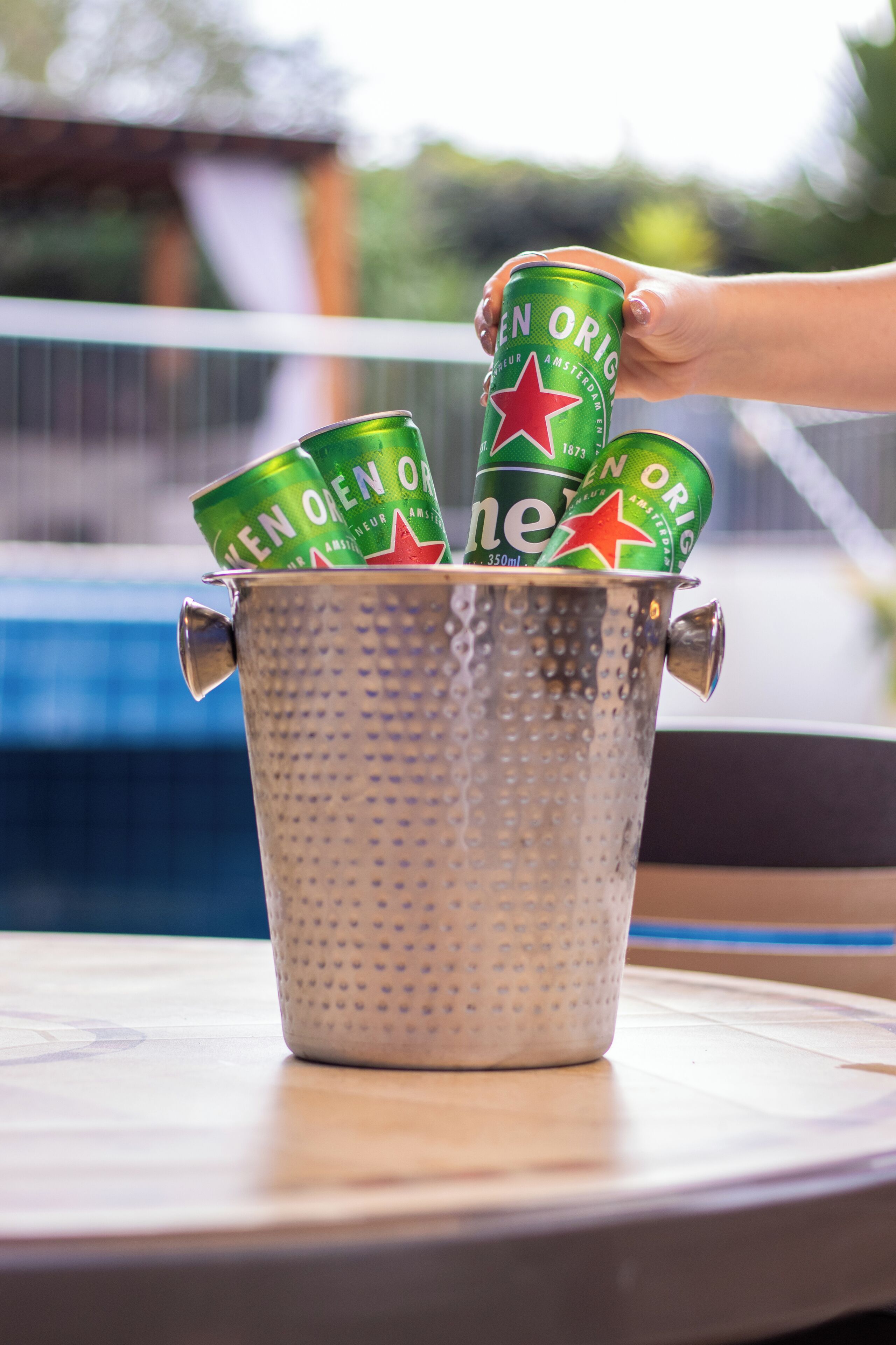 Un seau en métal contenant plusieurs canettes de bière Heineken.