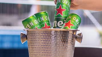 Un seau en métal contenant plusieurs canettes de bière Heineken.