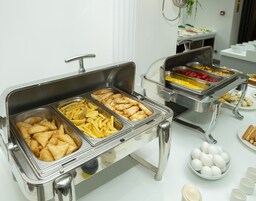 A buffet with various food options including fried items, French fries, and eggs.