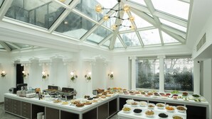Ein geräumiges Zimmer mit großem Frühstücksbuffet, einem Oberlicht und Blick ins Freie.