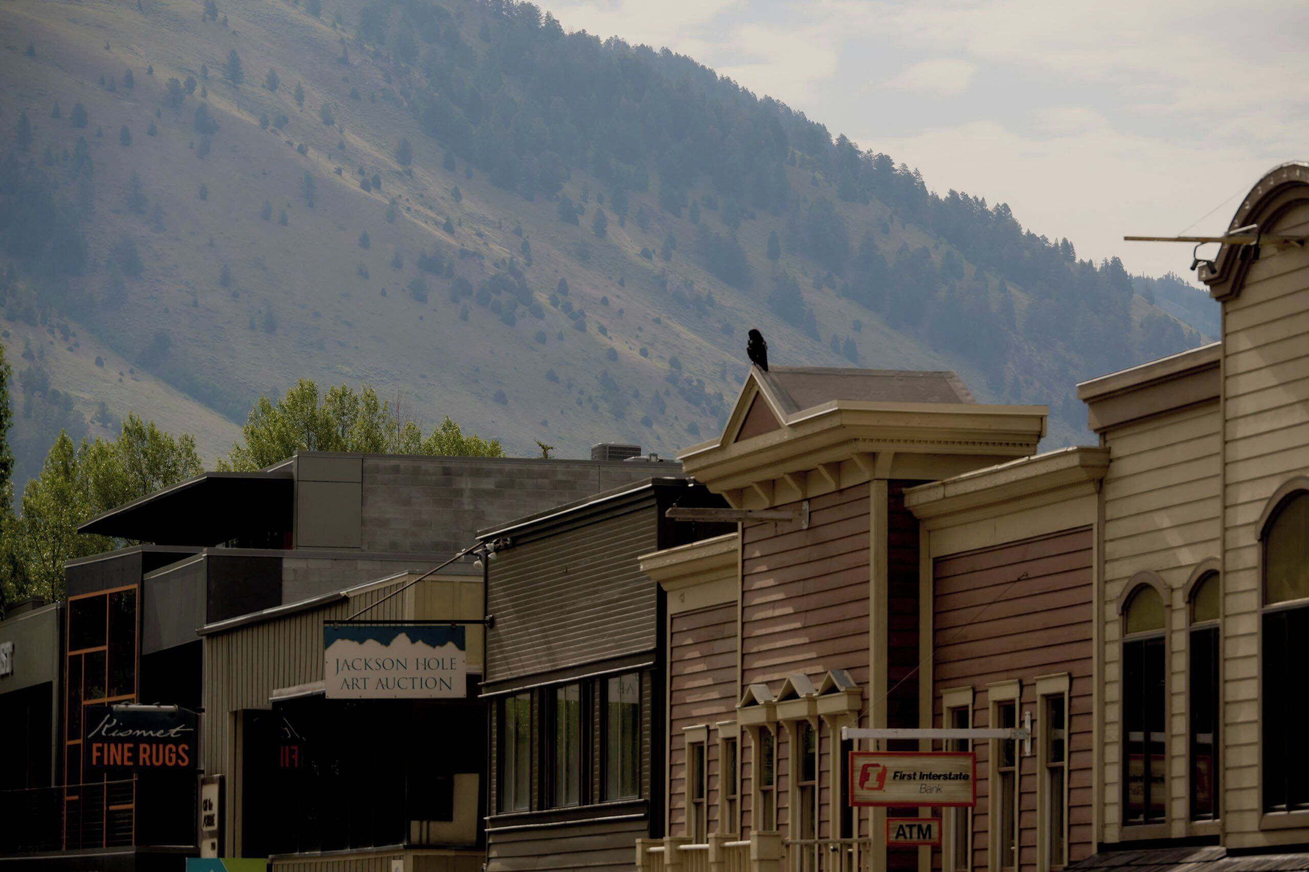 A building with a sign for 'Jackson Hole Art Auction' and a First Interstate Bank ATM.