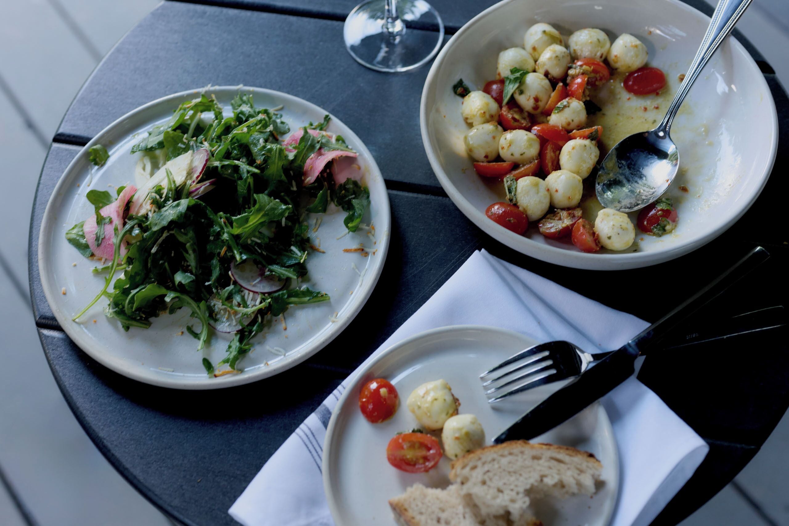 Une table avec deux assiettes de nourriture, un verre d’eau et des couverts.