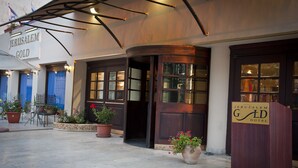 The exterior of the Jerusalem Gold Hotel with a curved entrance, potted plants, and a signboard. - Jerusalem Gold Hotel (Jerusalem)
