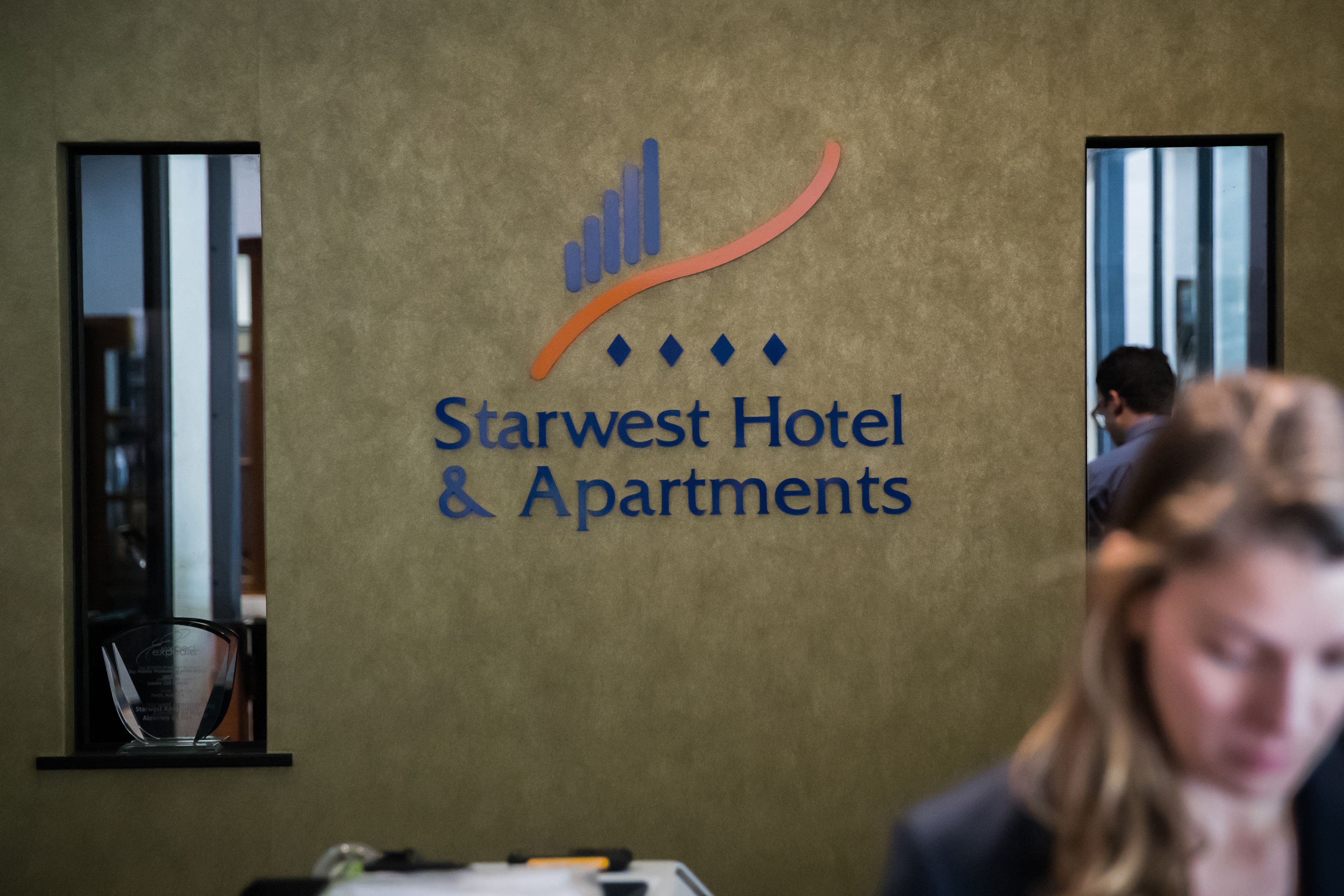 Eine Wand mit dem Logo und dem Namen Starwest Hotel & Apartments.