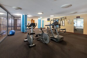 A gym with cardio machines, a blue exercise ball, and a mirrored wall. - Starwest Apartments Alderney on Hay (East Perth)