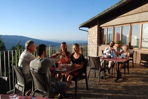 A group of people dining at an outdoor table with a view of the mountains. - Hotel Rifugio Prategiano (Montieri)