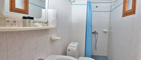 A bathroom with a white sink, toilet, and shower area.