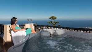 A woman sitting by a hot tub with a view of the ocean. - Aelia by Eltheon (Santorini)