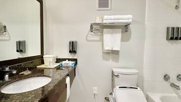 A modern bathroom with two sinks, a toilet, a bathtub, and a shower.