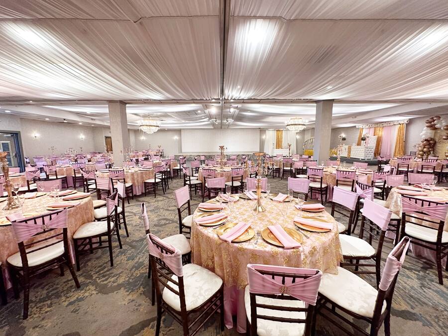 Un salón de banquetes con mesas redondas, sillas y candelabros.