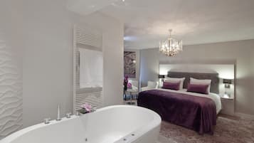 Ein modernes Badezimmer mit freistehender Badewanne, einem großen Spiegel und einer Chandelier.