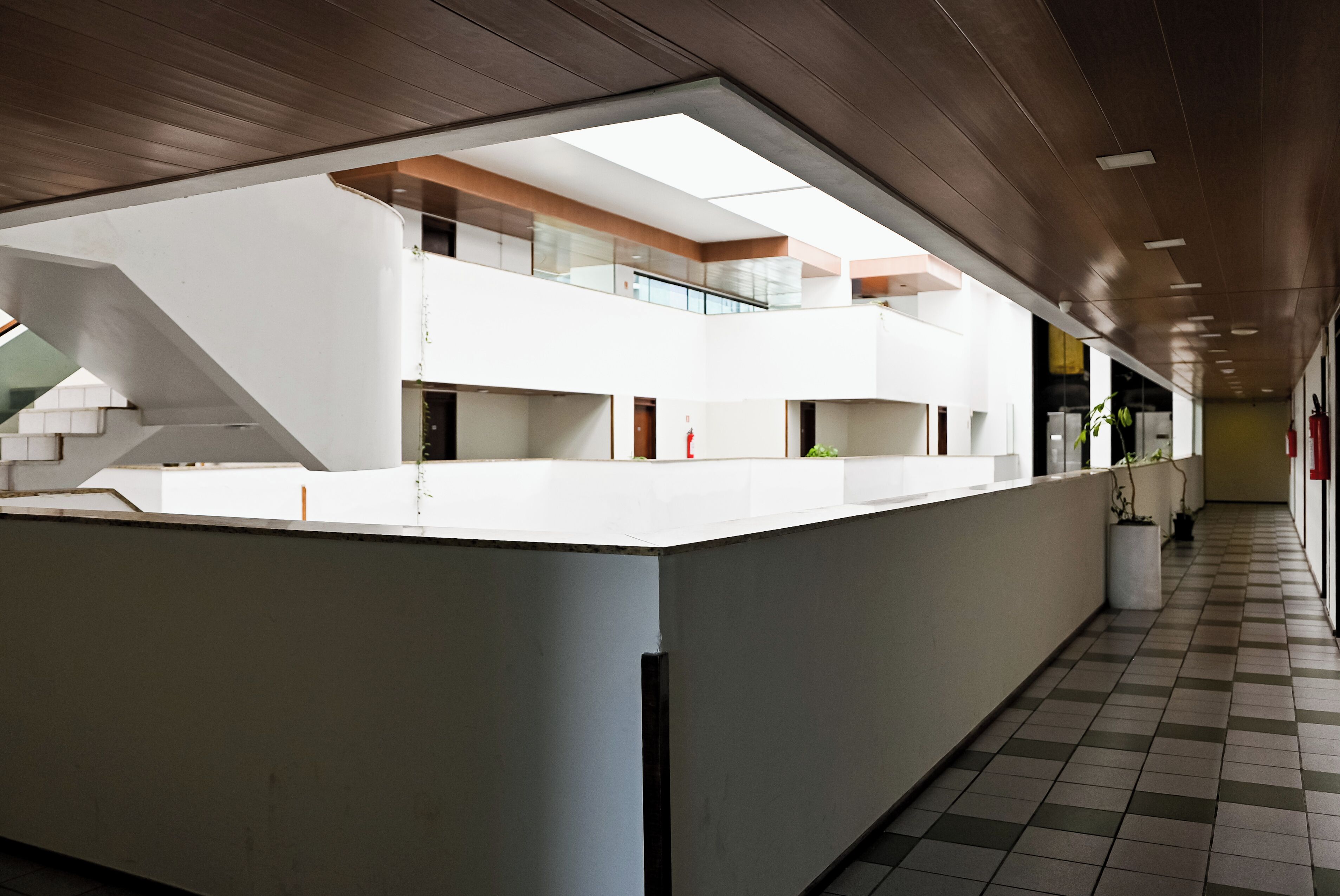 Ein modernes Interieur mit einer zentralen Rezeption, einer Treppe und einem Schachbrettmuster-Boden.