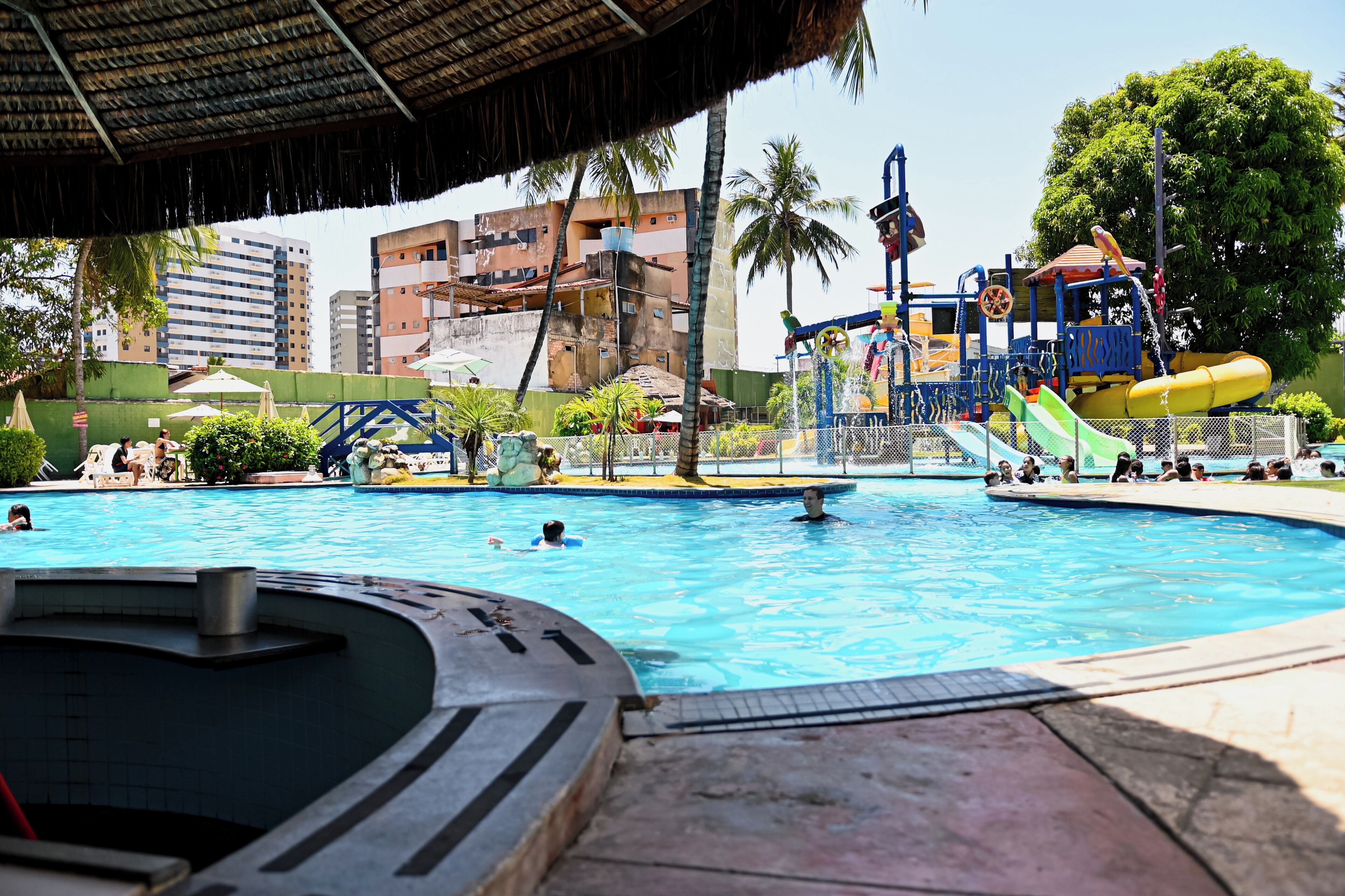 Ein Schwimmbecken mit Whirlpool, Rutschen und einem Spielbereich.