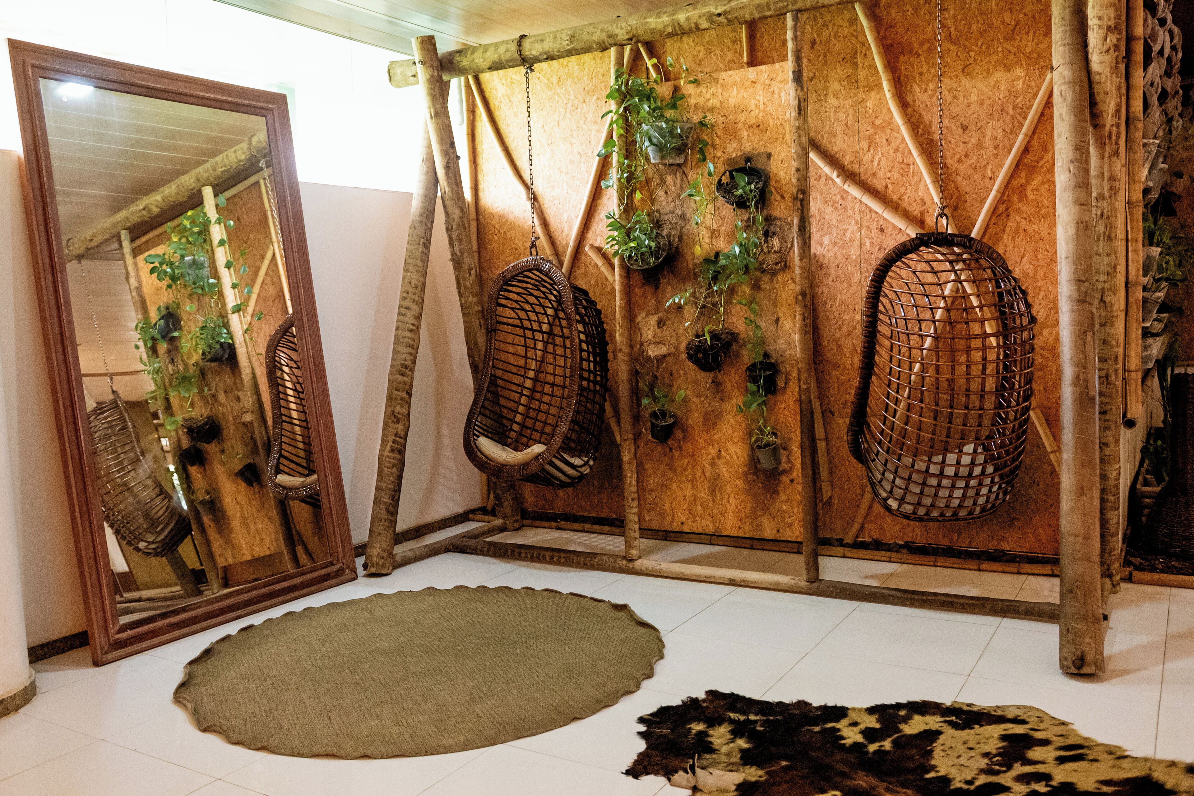 A room with a wooden wall, a large mirror, and a woven chair.