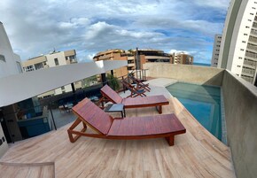 Una piscina al aire libre, tumbonas