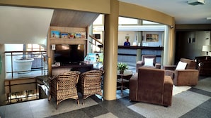 A spacious lobby with a seating area, a reception desk, and a large television screen. - Costa Do Atlantico (Natal)