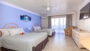 A hotel room with two beds, a ceiling fan, a flat-screen TV, and a dining area with a chair and a small table. - Bell Channel Inn Hotel (Freeport)