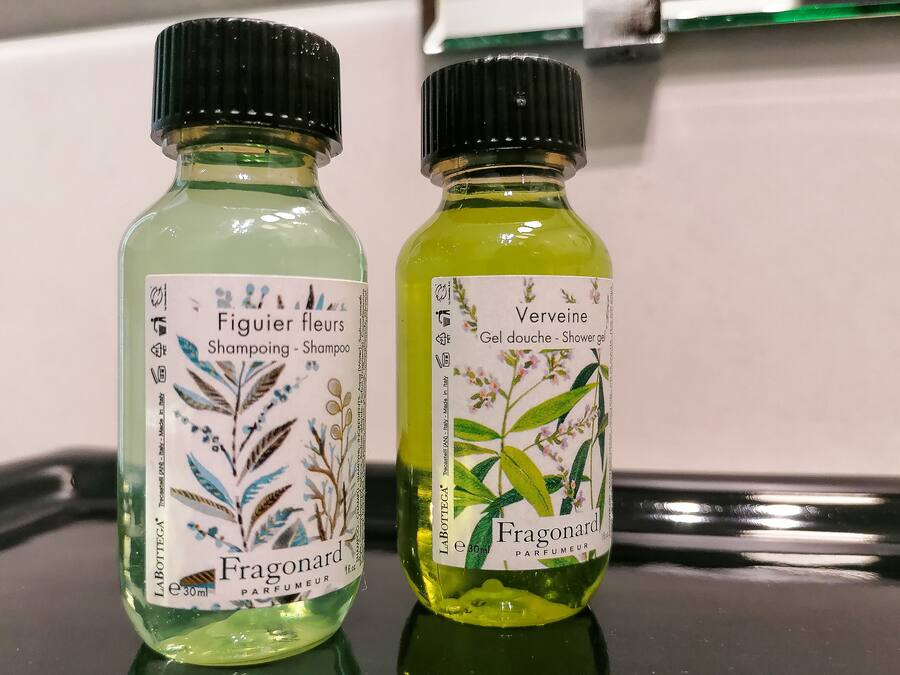 Dos botellas de perfume Fragonard sobre una superficie reflectante.