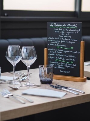 Un ambiente de restaurante con una pizarra que muestra un menú de varios platos y sus precios.