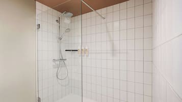 Um chuveiro moderno com porta de vidro, paredes revestidas de azulejos brancos e painel de controle visível.