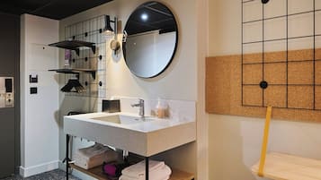 A modern bathroom with a large sink, mirror, and towel rack.