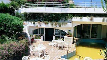 A rooftop patio with outdoor seating and a swimming pool.