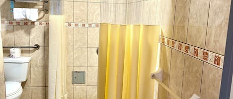 A bathroom with a shower curtain, a toilet, and a towel rack.
