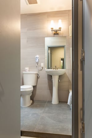 A bathroom with a toilet, bidet, and sink.